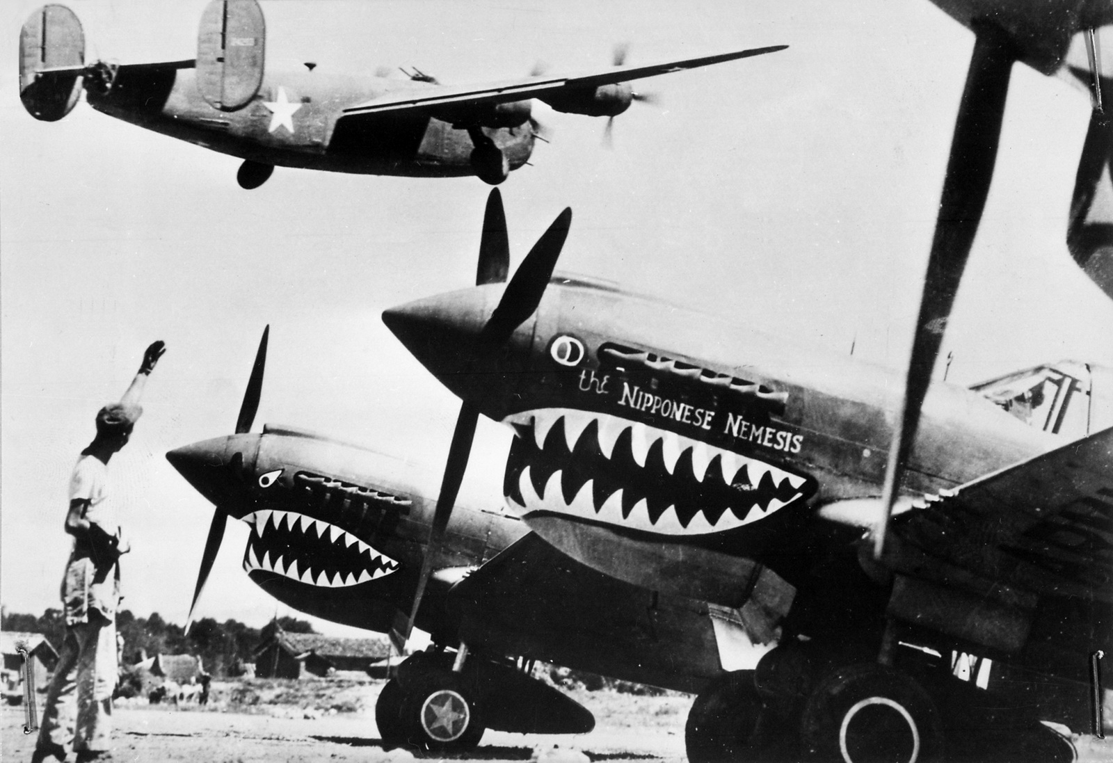 Copy+of+Landing+wheels+recede+as+this+U.S.+Army+Air+Forces+Liberator+bomber+crosses+the+shark-nosed+bows+of+U.S.+P-40+fighter+planes.jpg